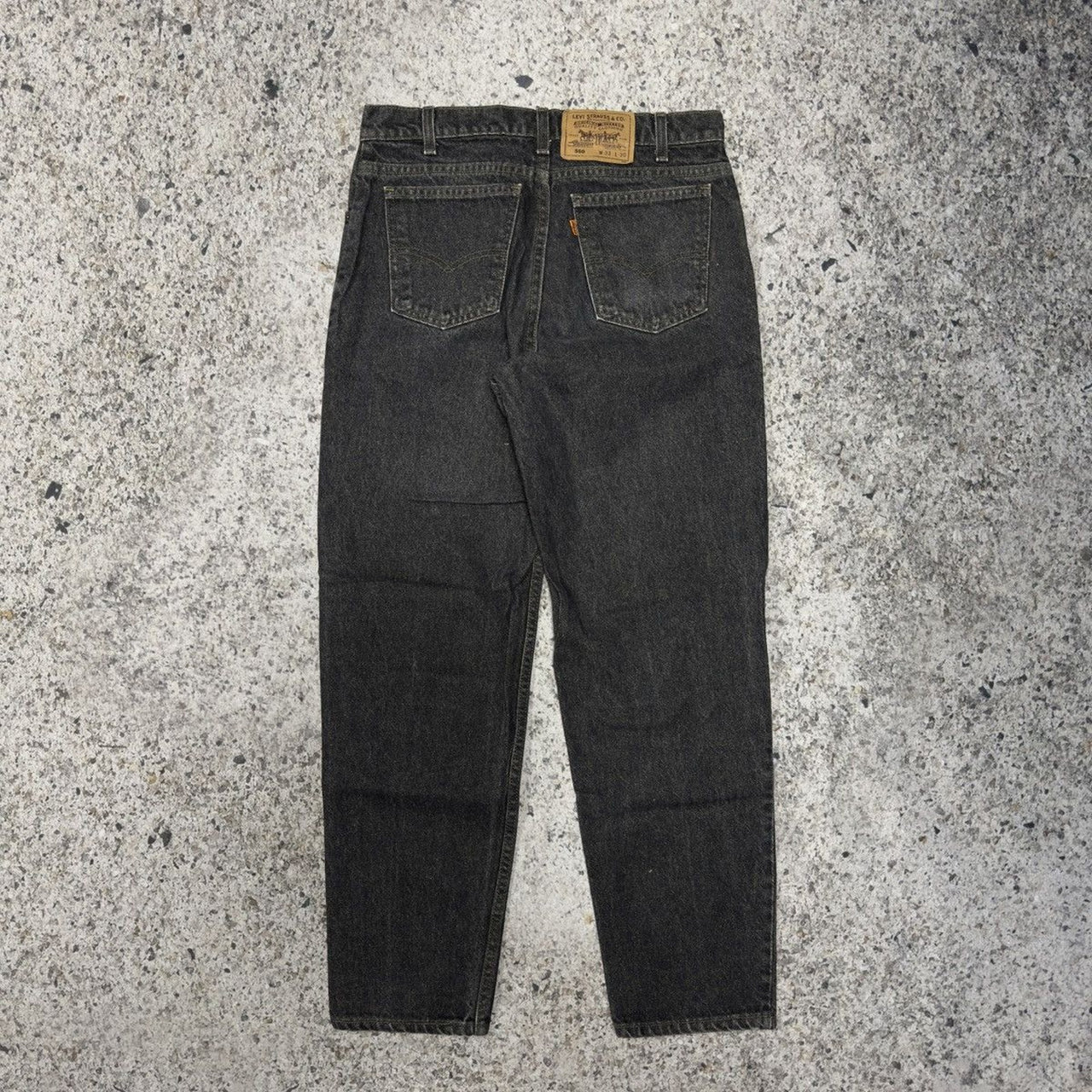Vaqueros Levi's 550 con lengüeta naranja y negro descolorido de la década de 1990